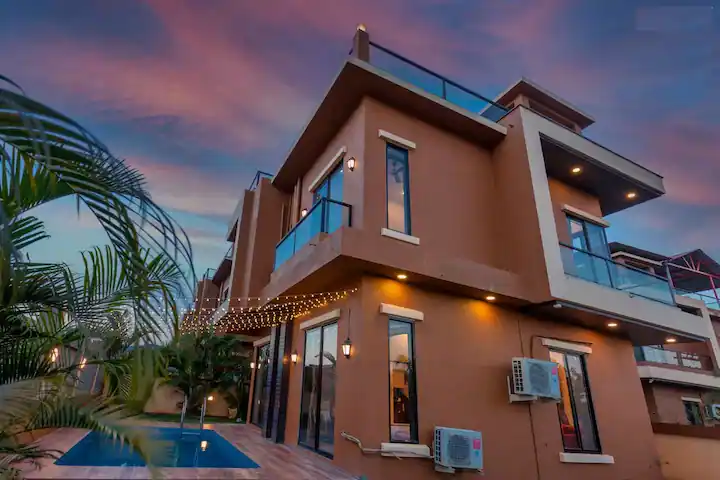 AquaStay luxury villa lit up at twilight in Lonavala